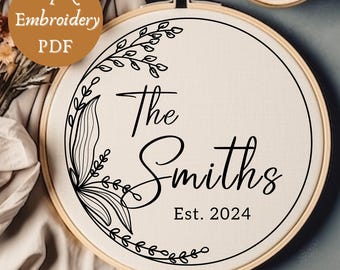May include: A white embroidery hoop with a black floral design and the text "The Smiths Est. 2024".