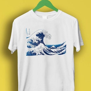 Może przedstawiać: Biała koszulka z niebiesko-białym nadrukiem Wielkiej Fali Kanagawa autorstwa Katsushiki Hokusai.