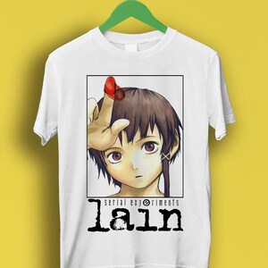 May include: White t-shirt with a graphic of a girl with brown hair and red eyes. The graphic is in a white square with the text "serial experiments lain" below it.