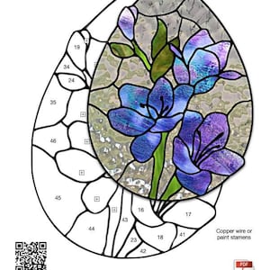 May include: A stained glass pattern of a teardrop-shaped design featuring a cluster of purple freesia flowers with green leaves. The pattern is labeled "Freesia Teardrop" and includes numbered sections for glass cutting. The pattern is 6 inches by 8 1/4 inches.