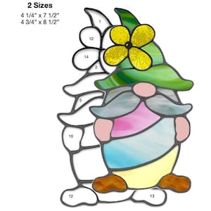 May include: A stained glass pattern for an Easter egg gnome. The pattern includes 14 pieces of glass in various colors, including green, yellow, pink, blue, and brown. The pattern is available in two sizes: 4 1/4 inches by 7 1/2 inches and 4 3/4 inches by 8 1/2 inches.