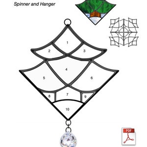 May include: A black and white line drawing of a stained glass Christmas tree pattern with 10 numbered sections. The tree is a spinner and hanger with a crystal prism hanging from the bottom. The text "Christmas Tree" and "Spinner and Hanger" are at the top of the image. The text "Down East Stained Glass" is at the bottom of the image.