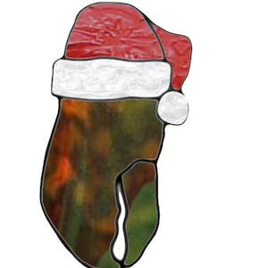 May include: A stained glass Christmas ornament in the shape of a Santa hat. The hat is red with a white trim and a white pom-pom. The body of the ornament has a colorful, abstract design with green, brown, and orange hues.
