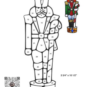 Peut inclure: Un motif de casse-noisette en noir et blanc avec 49 sections numérotées. Le motif mesure 3 3/4 pouces par 10 1/2 pouces. Le titre "Casse-noisette" est en haut du motif.
