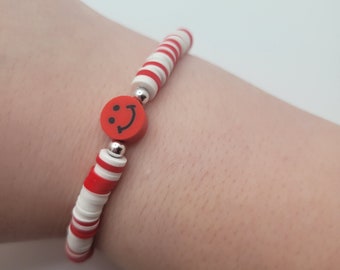 1 white and red bracelet with a red smiley face