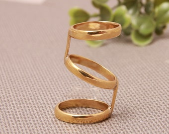 Op de afbeelding: Een gouden ring met een uniek ontwerp met dubbele lus. De ring is gemaakt van metaal en heeft een gladde, gepolijste afwerking.
