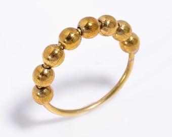 May include: A gold ring with a series of round beads.