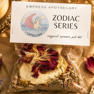 May include: A clear plastic pouch containing dried flower petals, herbs, and fruit slices. The white header card reads EMPRESS APOTHECARY ZODIAC SERIES CAPRICORN and magical summer pot kit, featuring a circular illustration of a sea-goat creature.