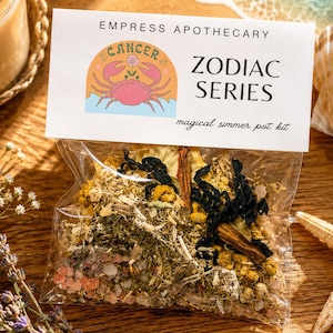 May include: A clear plastic pouch containing a mixture of dried herbs, flowers, and pink salt crystals. The header card reads EMPRESS APOTHECARY ZODIAC SERIES magical simmer pot kit and features a graphic of a pink crab with the word CANCER.