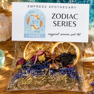 May include: A clear plastic pouch containing a simmer pot kit labeled Empress Apothecary Zodiac Series Pisces. The kit includes dried orange slices, star anise, dried flower petals, lavender, and herbs. The header card features a Pisces illustration.