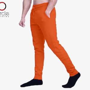 May include: Orange sweatpants with a drawstring waist. The sweatpants are made of a soft, comfortable fabric and have a relaxed fit.