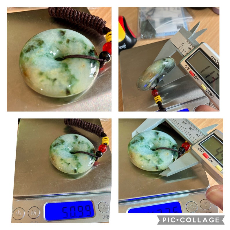 May include: A green jade pendant in the shape of a donut with a hole in the center. The pendant is on a scale that reads 50.99 grams. The pendant is also being measured with a caliper that reads 42.7 mm.