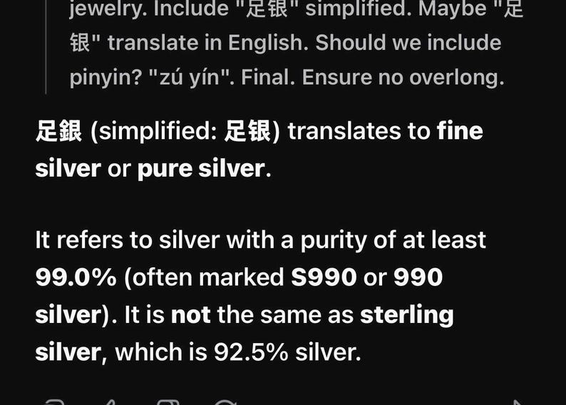 Pode incluir: Um fundo preto com texto branco explicando o termo 足银, que se traduz como prata fina ou prata pura. O texto especifica que se refere a prata com uma pureza de pelo menos 99,0%, frequentemente marcada como S990 ou prata 990, distinta da prata esterlina.