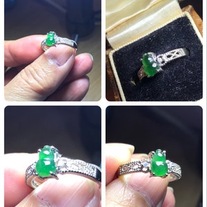 May include: A silver ring with two green jade stones and small diamonds set in a delicate filigree design.