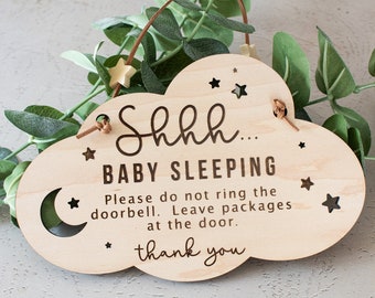 May include: A wooden sign shaped like a cloud with the text "Shhh... Baby Sleeping. Please do not ring the doorbell. Leave packages at the door. Thank you." The sign has a crescent moon and stars cut out.