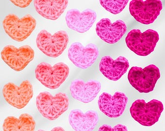 May include: A pattern of crocheted hearts in shades of pink, red, and orange. The hearts are arranged in rows, with the darkest hearts at the bottom and the lightest hearts at the top.