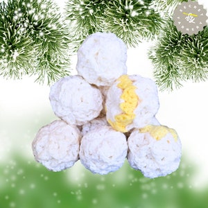 May include: A pile of crocheted white and yellow snowballs. The snowballs are arranged in a pyramid shape.