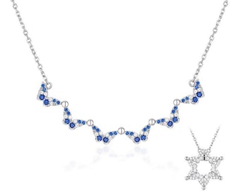 May include: A silver necklace with a delicate chain and a pendant featuring a star of David design. The pendant is adorned with small blue and white gemstones.