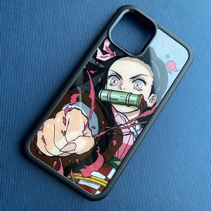 Peut inclure: Coque de t&eacute;l&eacute;phone noire avec une illustration color&eacute;e d'un personnage d'anime. Le design pr&eacute;sente un personnage aux yeux roses, une museli&egrave;re en bambou et une pose dynamique avec un poing serr&eacute;. La coque a une bordure noire.