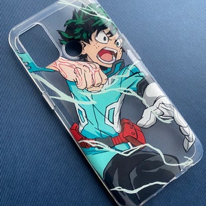 Peut inclure: Coque de t&eacute;l&eacute;phone transparente avec une illustration dynamique d'un personnage aux cheveux verts et une tenue bleu sarcelle et noire. Le personnage est en pleine action, avec des lignes d'&eacute;nergie blanches. La coque a une ceinture rouge et des gants blancs.