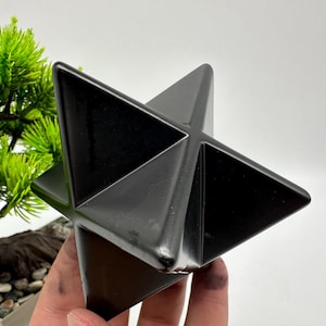 May include: A black obsidian star shaped crystal, also known as a Merkaba, is a geometric shape that is often used in meditation and healing.