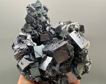 May include: A cluster of dark gray galena crystals with a metallic sheen. The crystals are cubic and clustered together, with some areas of white quartz. The overall shape is irregular and textured, with a natural, raw appearance.