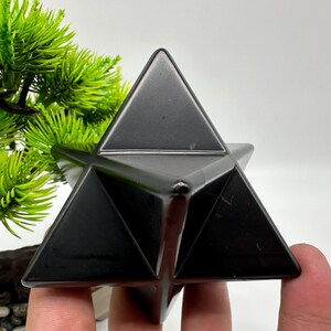 May include: A black obsidian star shaped crystal, also known as a Merkaba, is a geometric shape that is often used for meditation and energy work.