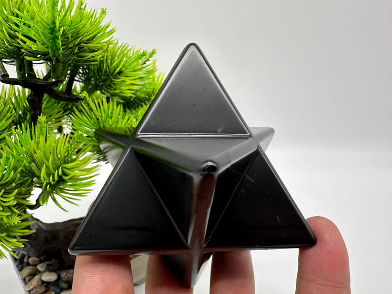 May include: A black obsidian star shaped crystal, also known as a Merkaba, is a geometric shape that is often used for meditation and energy work.