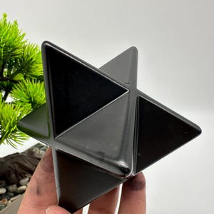 May include: A black obsidian star shaped crystal, also known as a Merkaba, is a geometric shape that is often used in meditation and healing.