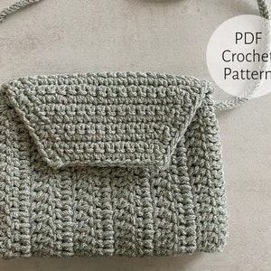 Puede incluir: Un bolso de crochet verde con cierre de solapa y una correa larga. El bolso está hecho con un punto texturizado y tiene un diseño simple y minimalista. Patrón de crochet PDF.