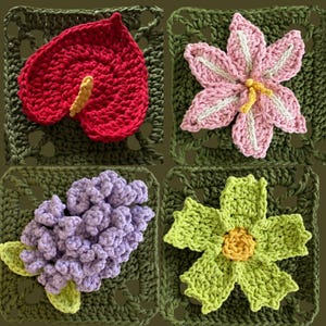 May include: A collection of four crocheted floral designs. The designs include a red anthurium, a pink and white lily, a cluster of purple lilacs, and a green and yellow flower, all set on green crocheted squares.