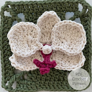 May include: A crochet pattern for a white orchid flower with a pink center. The flower is on a green crochet square background. The text "PDF Crochet Pattern" is in the lower right corner of the image.