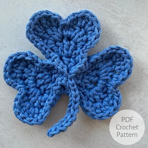 Könnte beinhalten: Ein blaues gehäkeltes Kleeblatt mit Stiel. PDF Häkelanleitung.