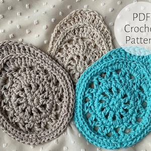 Może przedstawiać: Trzy szydełkowe podkładki, jedna beżowa, jedna jasnobrązowa i jedna turkusowa. Podkładki mają owalny kształt z okrągłym wzorem w środku. Obraz zawiera tekst "PDF Crochet Pattern".