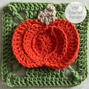 Könnte beinhalten: Eine gehäkelte orangefarbene Kürbis mit einem beigen Stiel liegt auf einem grünen gehäkelten Quadrat. Der Kürbis hat detaillierte Rippen. Der Text "PDF Crochet Pattern" befindet sich in einem weißen Kreis. Dies ist ein herbstliches Bastelprojekt.