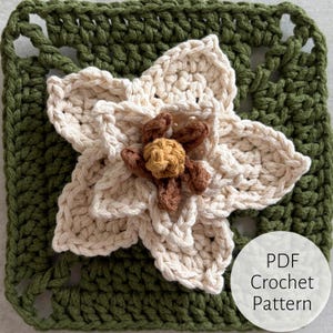 May include: A square, crocheted piece featuring a cream-colored flower with brown and yellow accents, centered on a green square. The text "PDF Crochet Pattern" is in a white circle in the lower right corner.