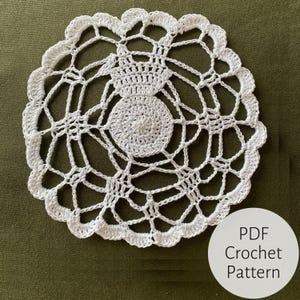 May include: White crochet doily with a delicate, intricate design. The doily is circular and has a scalloped edge. PDF Crochet Pattern.