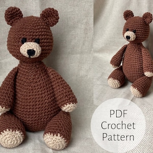 May include: A brown crocheted teddy bear with black eyes and a beige nose. The bear is sitting on a beige fabric surface. The text "PDF Crochet Pattern" is visible in the lower right corner of the image.