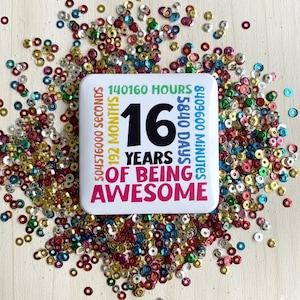 Könnte beinhalten: Ein weißer quadratischer Button mit dem Text "16 YEARS OF BEING AWESOME" in Schwarz und Rot, umgeben von bunten Pailletten. Der Button listet auch die entsprechende Zeit in Stunden, Sekunden, Monaten, Tagen und Minuten auf.