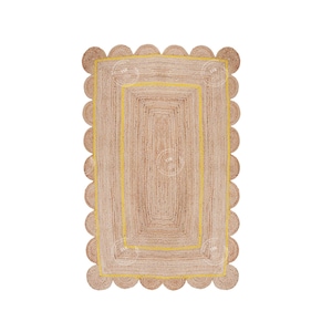 May include: A natural fiber rug with a scalloped edge and a yellow border. The rug has a rectangular shape and is made of woven jute.