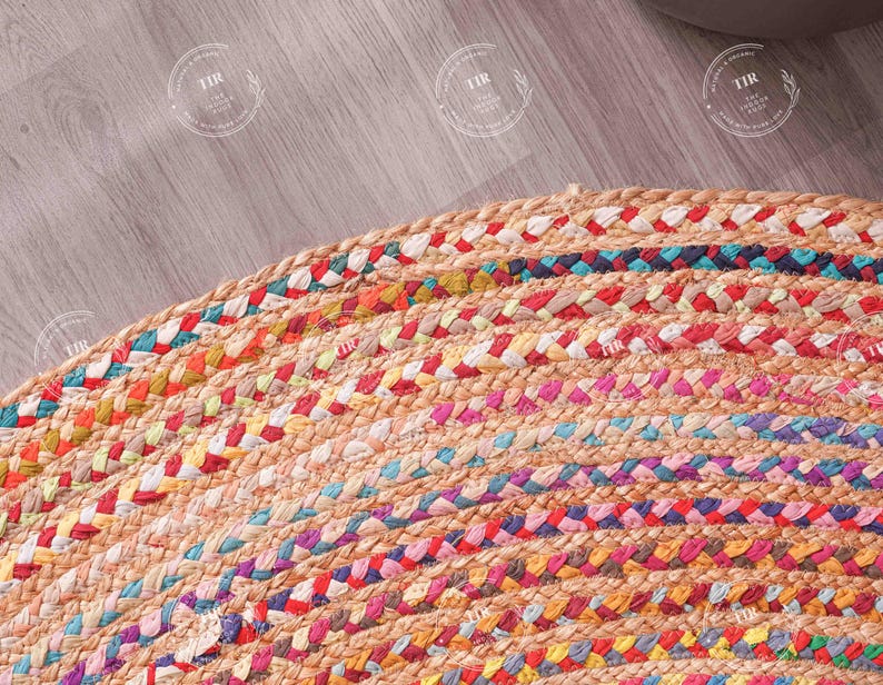K&ouml;nnte beinhalten: Nahaufnahme eines runden, geflochtenen Jute-Teppichs mit bunten Streifen. Der Teppich hat eine nat&uuml;rliche beige Basis mit B&auml;ndern in Rot, Blau, Gelb und Rosa. Die Textur des Teppichs ist sichtbar und zeigt die gewebte Konstruktion.