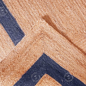 Peut inclure: Gros plan sur un tapis en fibres naturelles avec un motif en chevron. Le tapis est en jute et a des rayures bleu foncé.