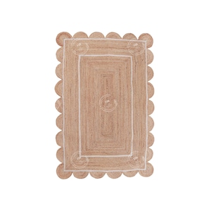 May include: A natural fiber rug with a scalloped edge and a white border. The rug is made of jute and has a natural, earthy color.