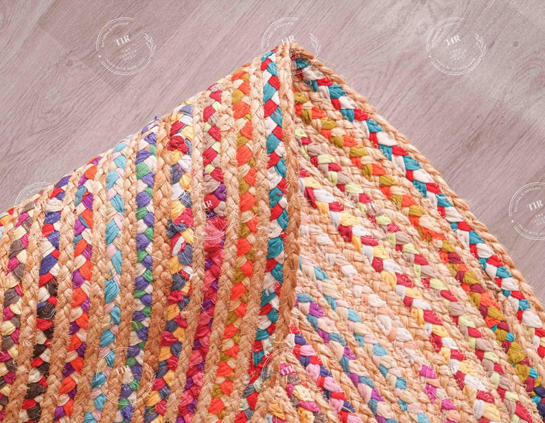 K&ouml;nnte beinhalten: Nahaufnahme eines farbenfrohen geflochtenen Jute-Teppichs. Der Teppich weist eine Mischung aus leuchtenden Farben auf, darunter Rot, Orange, Blau und Lila. Die Textur des Teppichs ist sichtbar und zeigt die Naturfasern und das komplizierte Webmuster.