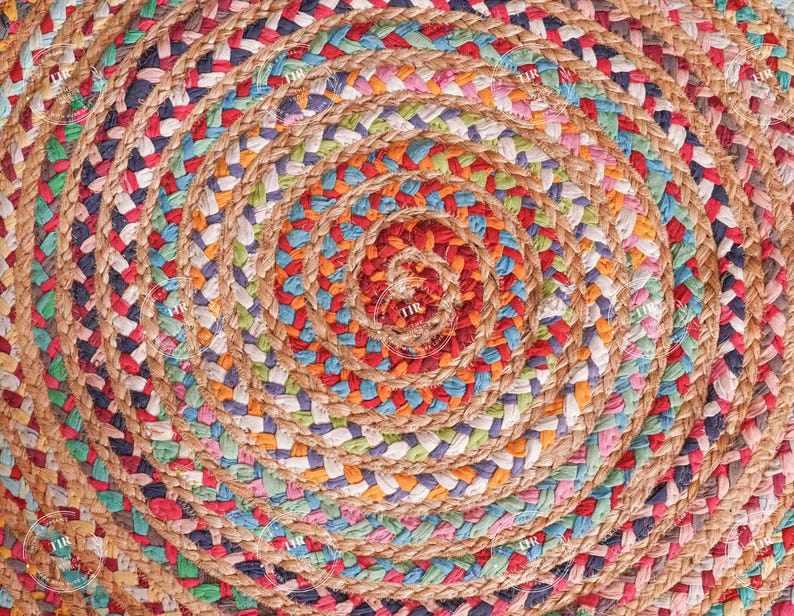K&ouml;nnte beinhalten: Ein runder Jute-Teppich mit Spiralmuster. Der Teppich hat eine nat&uuml;rliche beige Farbe mit eingewebten Abschnitten aus rotem, blauem, gr&uuml;nem und wei&szlig;em Stoff. Das Design erzeugt ein strukturiertes, farbenfrohes Muster f&uuml;r die Inneneinrichtung.