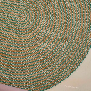 Puede incluir: Alfombra ovalada de yute con dise&ntilde;o trenzado. La alfombra presenta bandas alternas de color beige natural y verde, creando un patr&oacute;n decorativo texturizado. Esta alfombra es adecuada para uso en interiores.