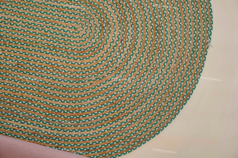 Puede incluir: Alfombra ovalada de yute con dise&ntilde;o trenzado. La alfombra presenta bandas alternas de color beige natural y verde, creando un patr&oacute;n decorativo texturizado. Esta alfombra es adecuada para uso en interiores.