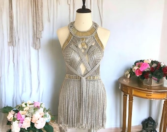 Vestido de festival de macramé: Traje egipcio plateado con tubos de metal dorado.