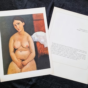 May include: A print of a nude woman by Modigliani, with a seated pose, in a painting style. The woman has pale skin, dark hair, and is seated with her hands clasped. The background features a dark wall and a red and white cloth.