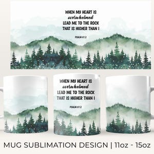 May include: White ceramic mug with a watercolor design of a forest with a quote that reads "When my heart is overwhelmed lead me to the rock that is higher than I Psalm 61:2".